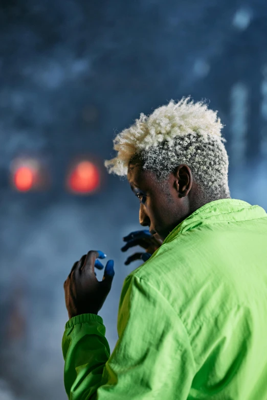 a man in a green jacket smoking a cigarette, an album cover, trending on unsplash, afrofuturism, crazy white hair, rapping on stage at festival, yellow spiky hair, square