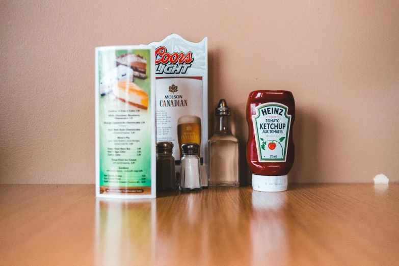 a bottle of ketchup next to a packet of ketchup, a still life, by Daniel Lieske, pexels, in classic diner, quebec, whipped cream on top, bottles of spices