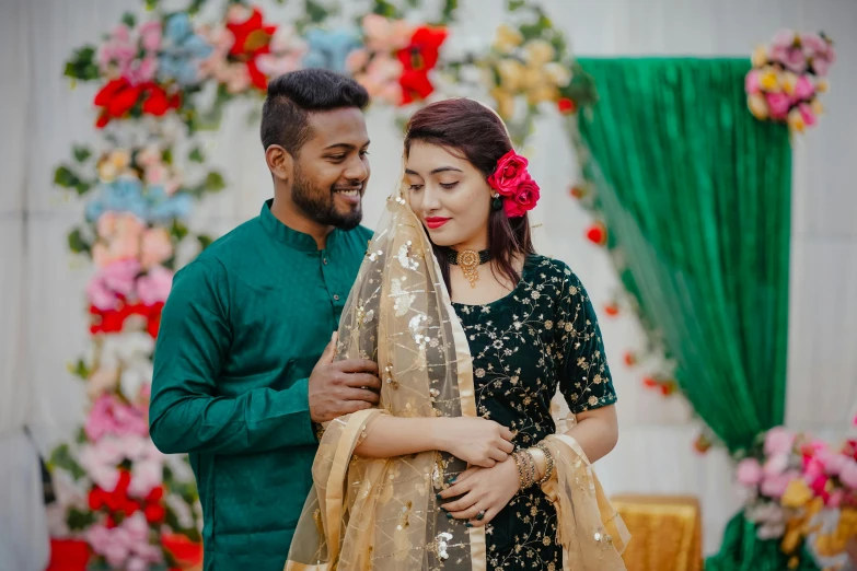 a man and a woman standing next to each other, pexels contest winner, hurufiyya, assamese aesthetic, wearing green suit, flowers and gold, attractive girl