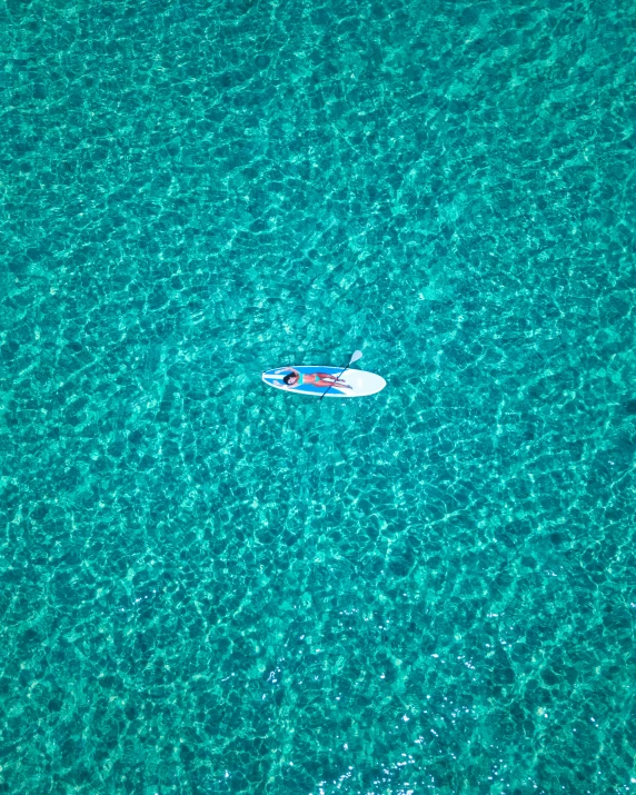 a person on a surfboard in the middle of the ocean, 256x256, top down photo, boat, cerulean
