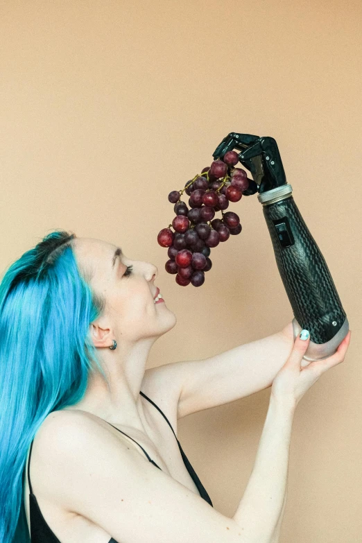 a woman with blue hair holding a bottle and a bunch of grapes, inspired by Elsa Bleda, unsplash, robotic prosthetic arm, better known as amouranth, seen from below, singularity sculpted �ー etsy