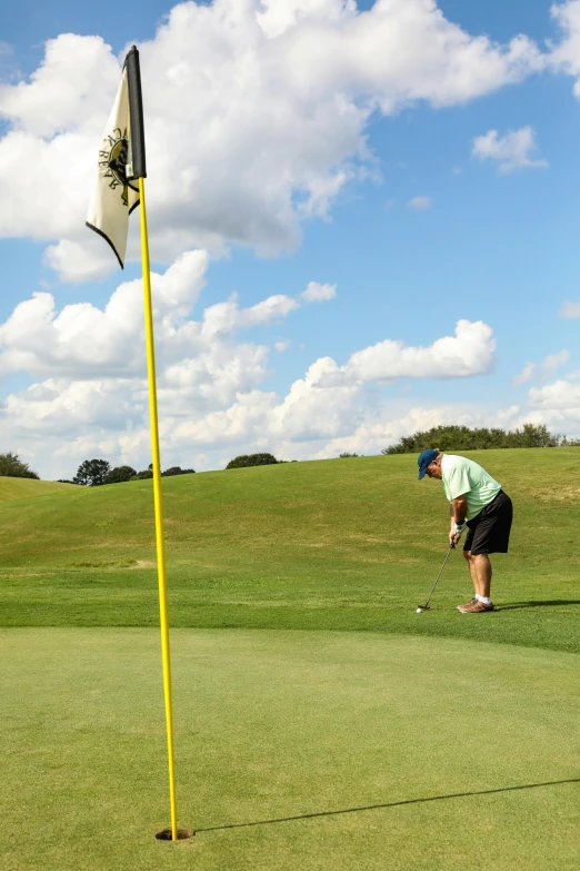 a man standing next to a yellow flag on top of a green field, tournament, off - putting, thumbnail, craigville