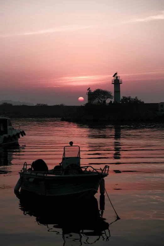 a couple of boats that are sitting in the water, by Rajesh Soni, romanticism, pink sunlight, low quality photograph, indore, lighthouse