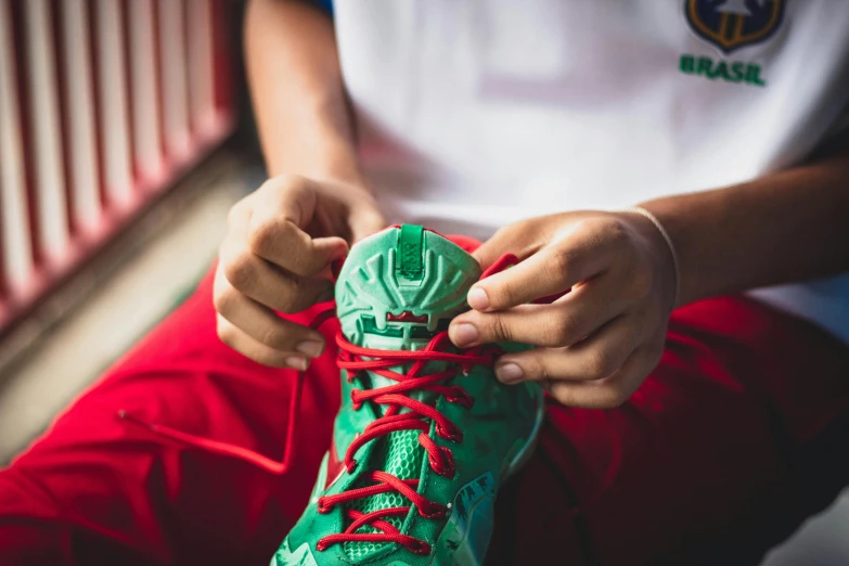 a person tying a shoe with red laces, pexels contest winner, boston celtics, avatar image, wearing festive clothing, stitching