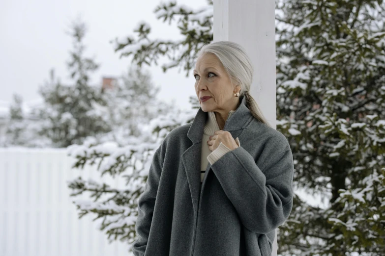 a woman is standing outside in the snow, inspired by Grytė Pintukaitė, pexels contest winner, photorealism, gray hair, still image from tv series, exterior shot, promotional image