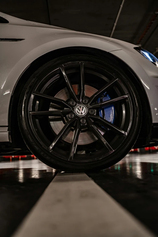 a white car sitting on top of a checkered floor, black wheel rims, high-quality photo, shot on sony a 7, ultra detailed close up