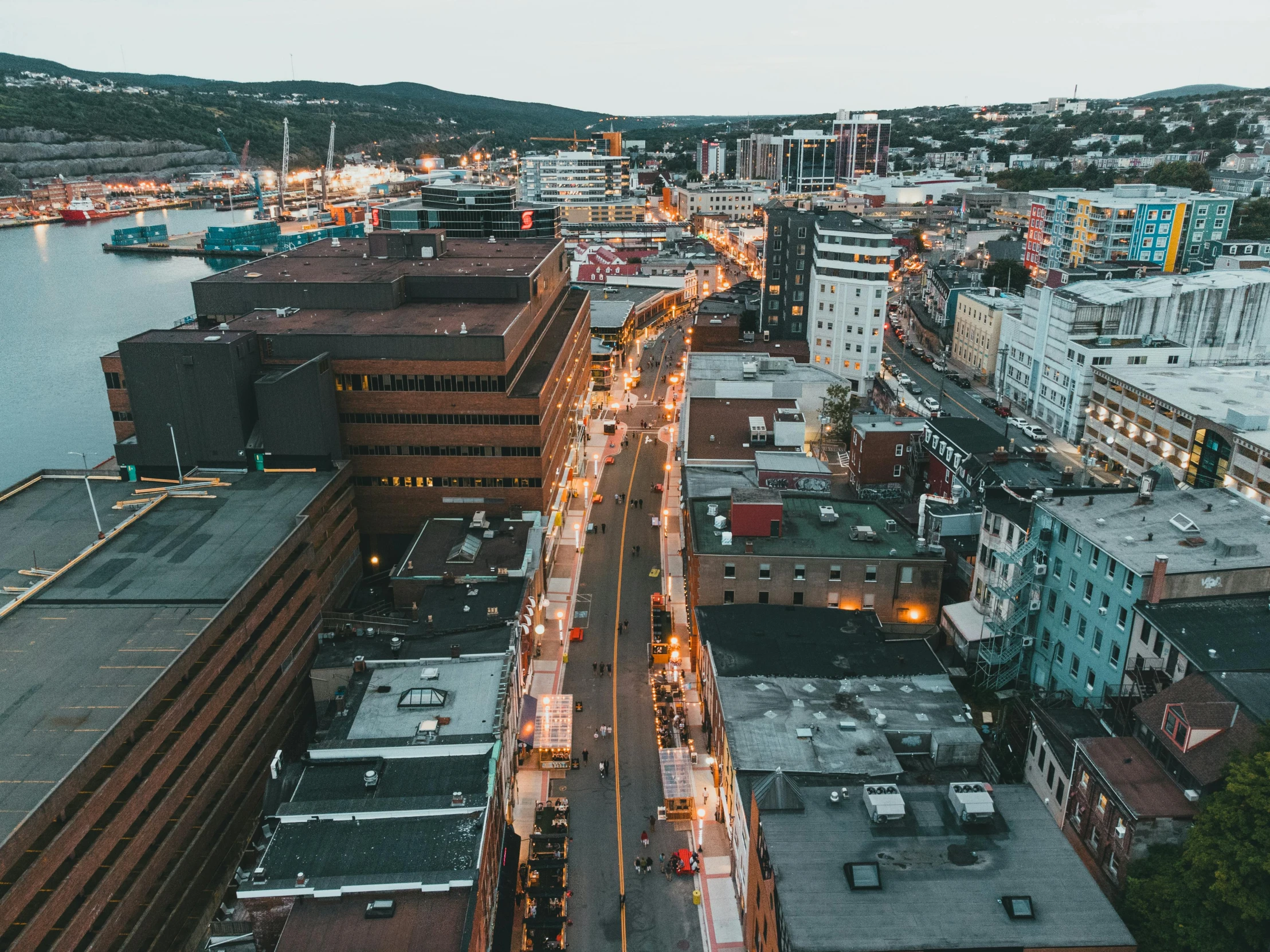 a view of a city from the top of a building, by Lee Loughridge, pexels contest winner, happening, quebec, wellington, city street at dusk, neo norilsk