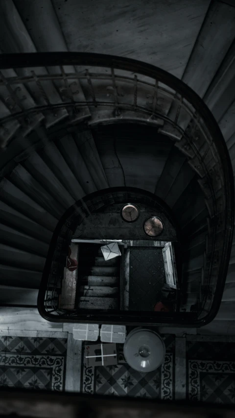 a black and white photo of a spiral staircase, an album cover, by Adam Szentpétery, unsplash contest winner, haunted house themed, high view, dark and desaturated colours, inside the sepulchre