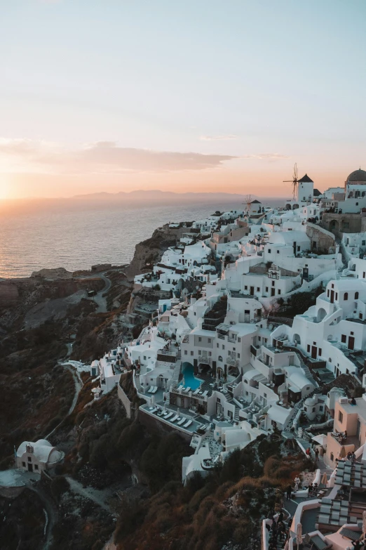 the sun sets over the village of oia on the greek island of santo, pexels contest winner, trending on vsco, staggered terraces, 2019 trending photo, ultrawide landscape