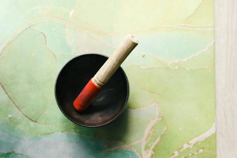 a cup with a cigarette sticking out of it, inspired by Tani Bunchō, unsplash, process art, mortar and pestle, green bright red, agate, high angle close up shot