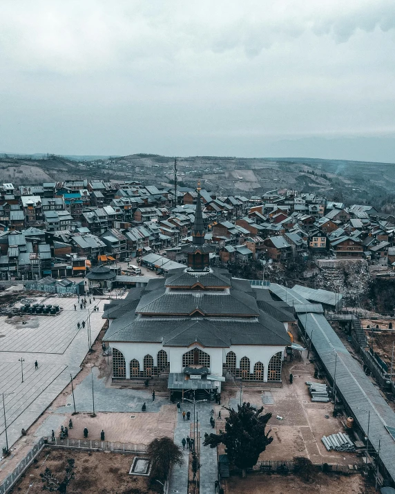 a large white building sitting on top of a dirt field, by Ismail Acar, pexels contest winner, hurufiyya, aerial view of a city, he is in a mosque, yggrdasil, color graded