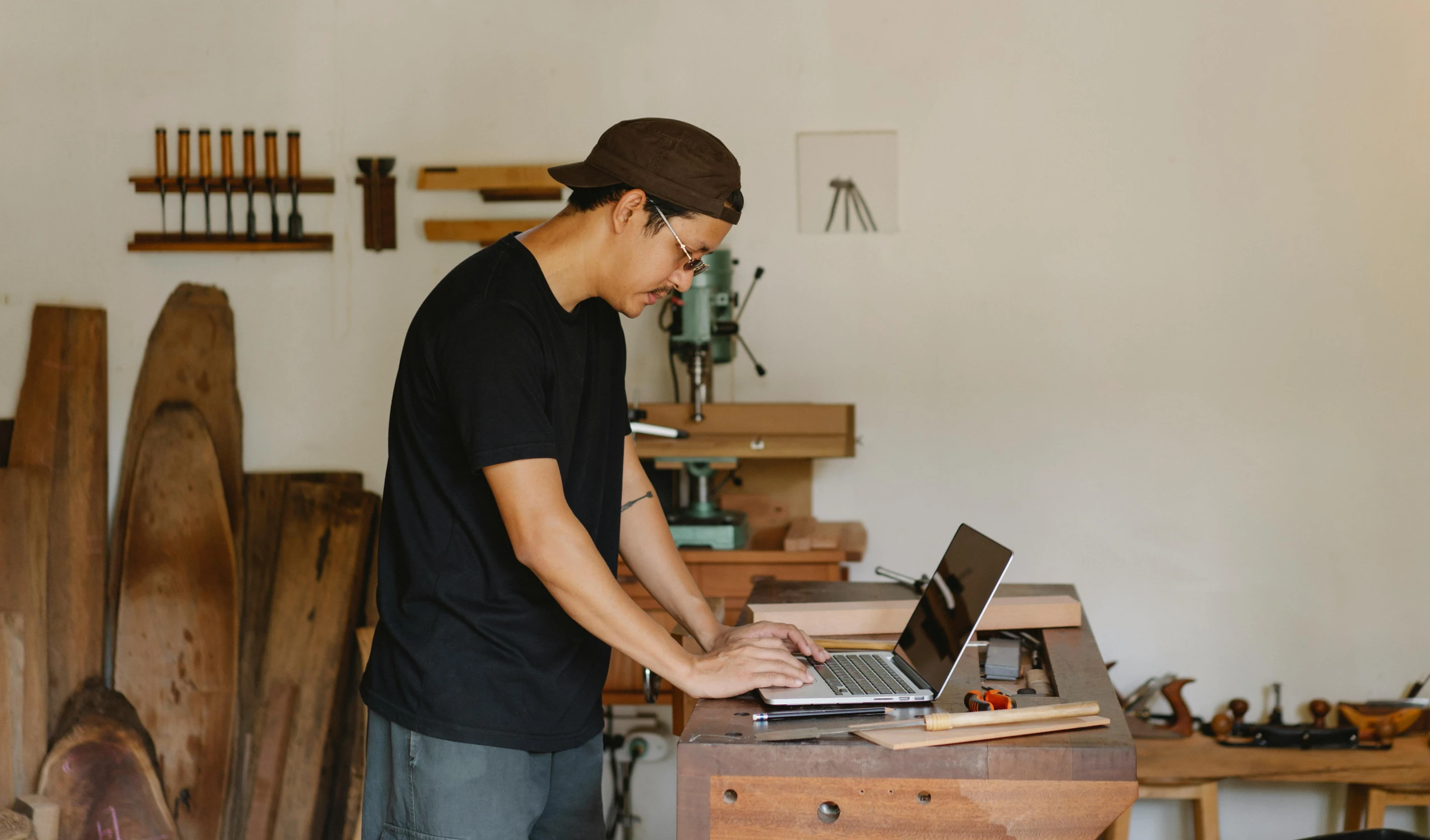 a man working on a laptop in a workshop, pexels contest winner, standing on a desk, 9 9 designs, carpenter, makoto