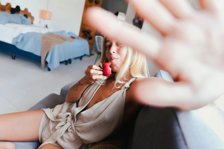 a woman sitting on a couch holding a cell phone, pexels contest winner, fight with strawberries, seducing the camera, alana fletcher, soft and blurry