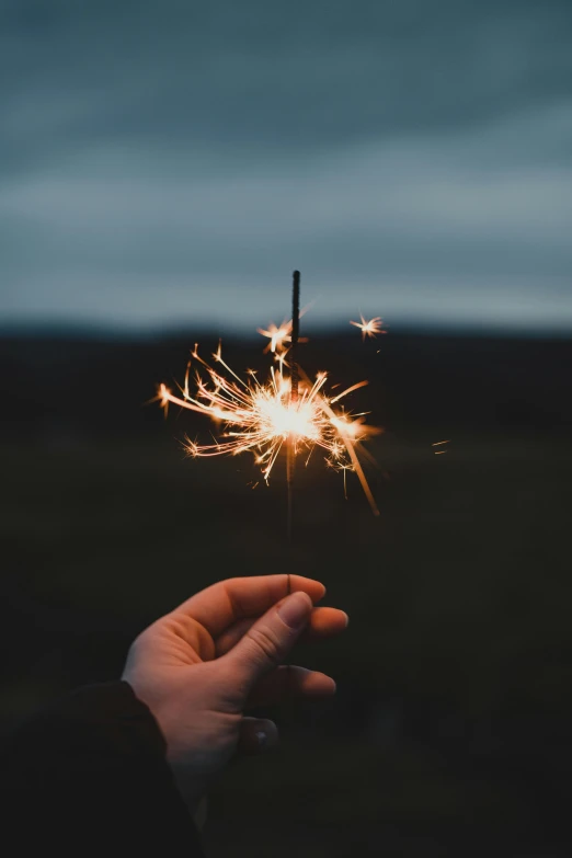 a person holding a sparkler in their hand, overlooking, photo taken in 2018, instagram post, magical notes