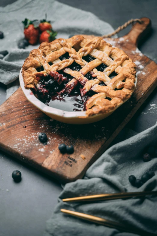 a pie sitting on top of a wooden cutting board, trending on unsplash, navy, “berries, soup, thumbnail