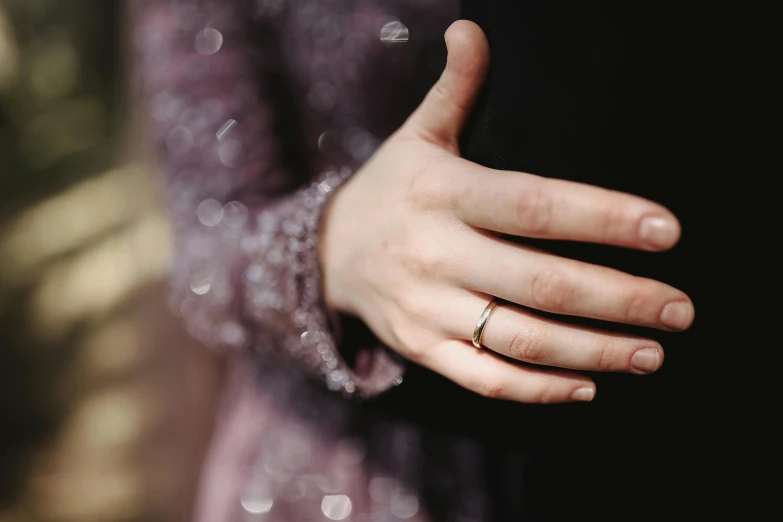 a close up of a person's hand with a ring on it, pexels, wearing a formal dress, gold and purple, instagram post, background image