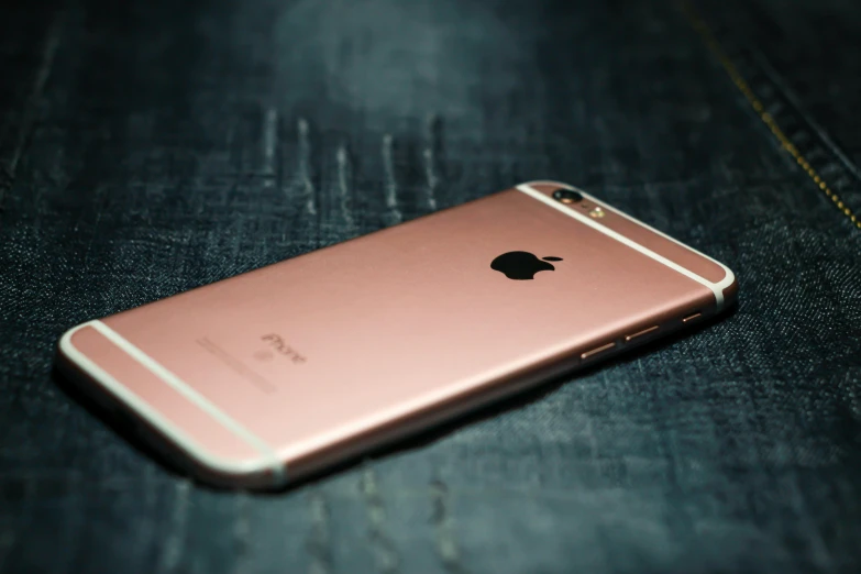 a pink iphone sitting on top of a pair of jeans, a picture, trending on pexels, renaissance, rose gold, with a black background, square, shot on iphone 6