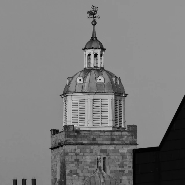 a black and white photo of a clock tower, a black and white photo, inspired by Christopher Wren, hiding in the rooftops, taken at golden hour, dome, cold top lighting