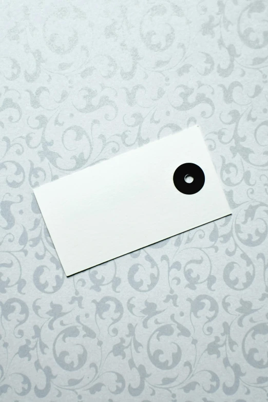 a piece of paper sitting on top of a table, arabesque, button eyes, ashford black marble, plain background, wedding