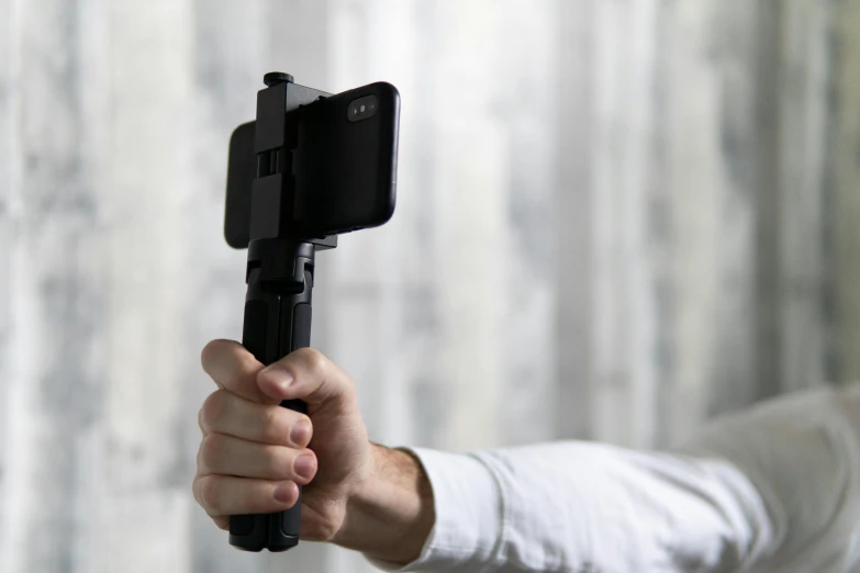 a close up of a person holding a cell phone, a picture, tripod, detailed product image, rotated, fan favorite