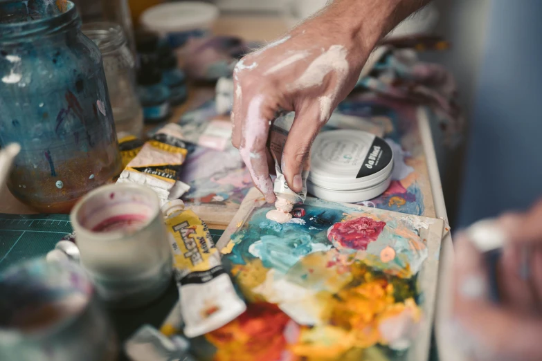 a close up of a person painting on a table, pexels contest winner, process art, can of paint, jeremy elbertson, 🎨🖌, palette knife