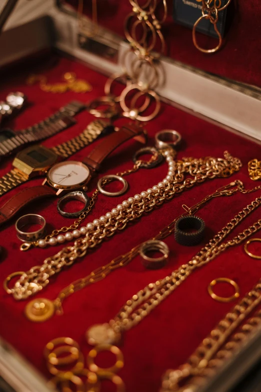 a case filled with lots of different types of jewelry, by Adam Marczyński, trending on pexels, red and golden color details, broken gold shackles, fine details portrait, (night)