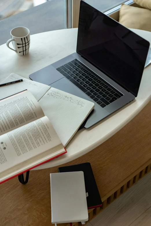 a laptop computer sitting on top of a wooden table, pexels, academic art, books on side table, circular, open office, half - turn