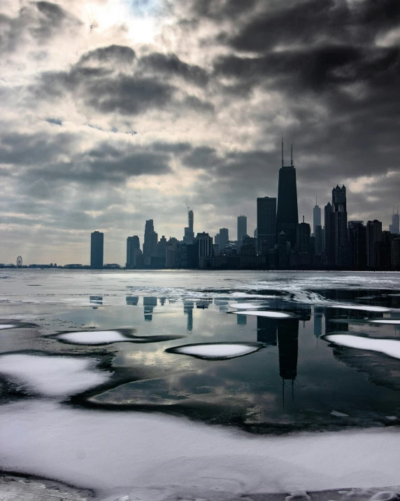 a large body of water with a city in the background, by Andrew Domachowski, unsplash contest winner, icicles, chicago, foreboding, dry ice