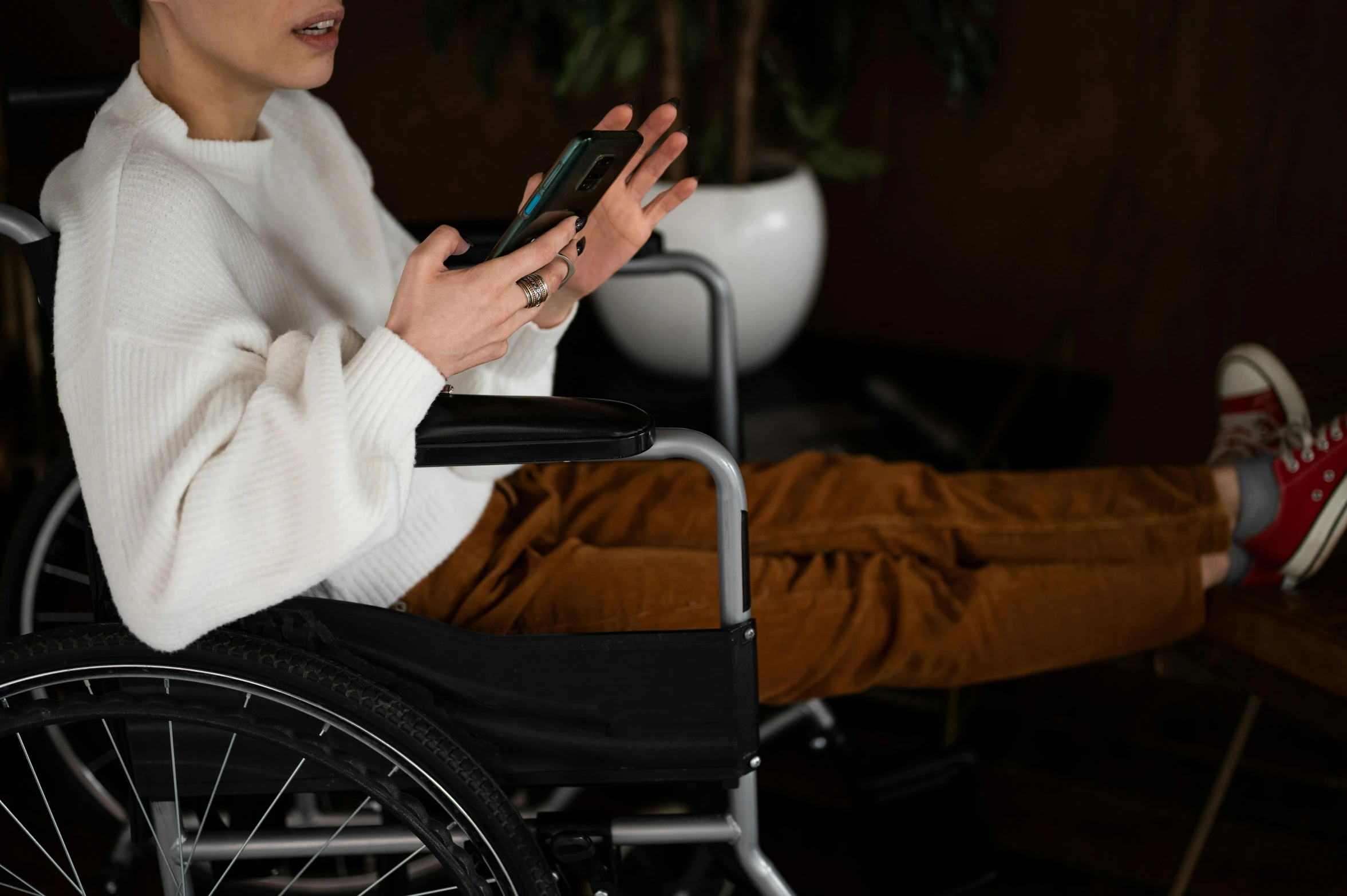 a woman sitting in a wheel chair using a cell phone, trending on pexels, hurufiyya, avatar image, no extra limbs, rectangle, high resolution
