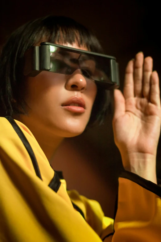 a close up of a person wearing a pair of glasses, inspired by Zhu Da, holography, with yellow cloths, reaching, immersive, lisa