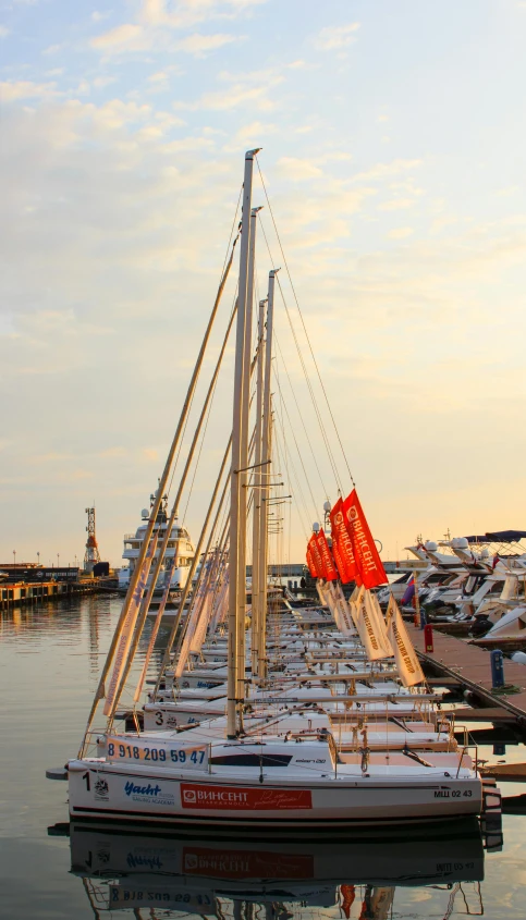 a number of boats in a body of water, by Carlo Martini, pexels contest winner, standing on the mast, at the waterside, where a large, sail