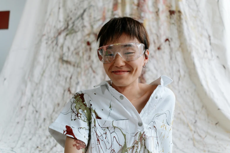 a woman in a lab coat and goggles holding a pair of scissors, a hyperrealistic painting, inspired by Shōzō Shimamoto, pexels contest winner, gutai group, bjork smiling, artist wearing torn overalls, marbling, yin zhen chu