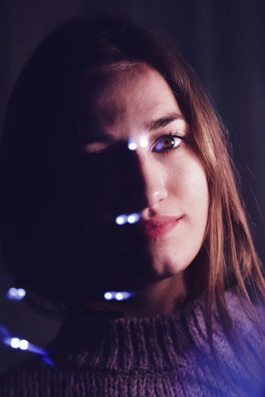 a woman holding a string of lights in front of her face, a picture, by Adam Marczyński, pexels contest winner, holography, jaina solo, self - satisfied smirk, full close-up portrait, light stubble