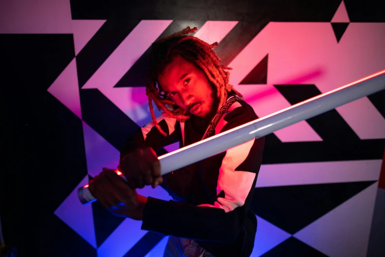 a man holding a sword in front of a wall, unsplash, afrofuturism, neon lights in the background, wiz khalifa, geometric backdrop; led, activity with fight on swords