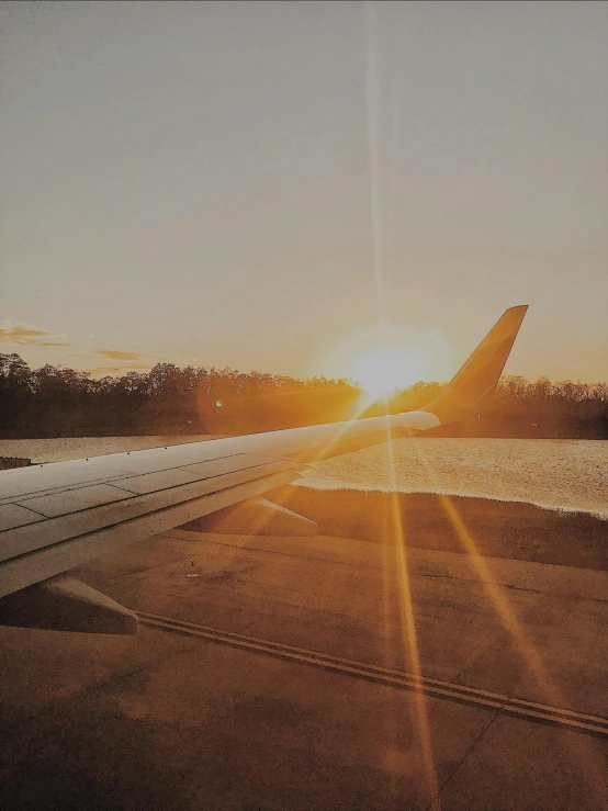 a large jetliner sitting on top of an airport tarmac, by Carey Morris, pexels contest winner, rays of sunshine, trending on vsco, golden sunset, profile picture