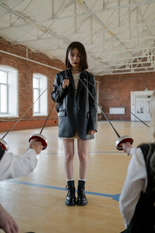 a group of people standing on top of a wooden floor, by Fei Danxu, kinetic art, she wears leather jacket, fencing, ulzzang, private school