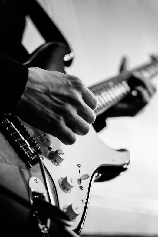 a close up of a person playing a guitar, by Dave Melvin, digitally remastered, black + white, electric guitar, uploaded