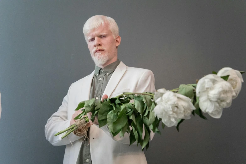 a man in a white suit holding a bunch of flowers, an album cover, inspired by Einar Hakonarson, intense albino, promo photo, silver，ivory, ignant