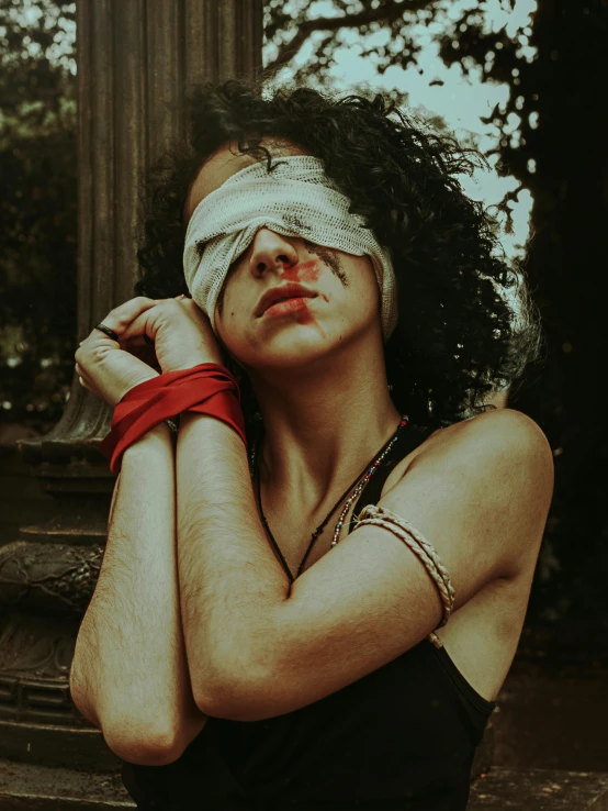 a woman with a bandage on her face, an album cover, inspired by Elsa Bleda, trending on pexels, renaissance, shibari, blindfold, red eye, low quality photo