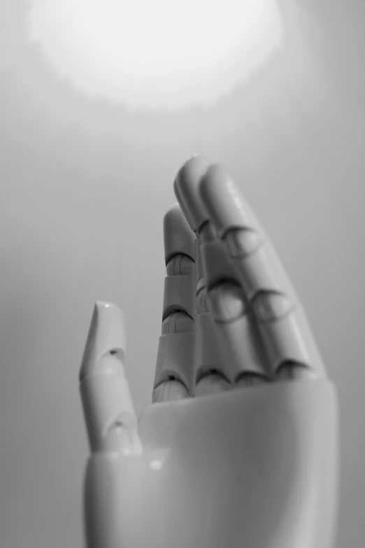 a black and white photo of a robotic hand, an ambient occlusion render, unsplash, aestheticism, doll in hand, morning lighting, singularity sculpted �ー etsy, posable pvc