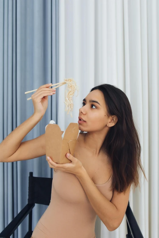 a woman is eating noodles with chopsticks, by Adam Marczyński, pexels contest winner, conceptual art, failed cosmetic surgery, candid photo of gal gadot, oona chaplin, gif