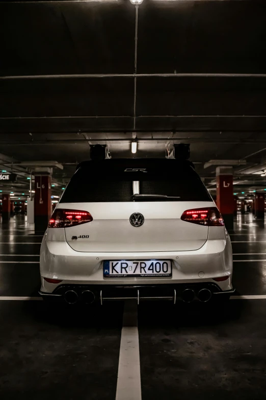 a white car parked in a parking garage, inspired by Jan Kupecký, pexels contest winner, wrx golf, rear lighting, horns with indicator lights, 🚿🗝📝