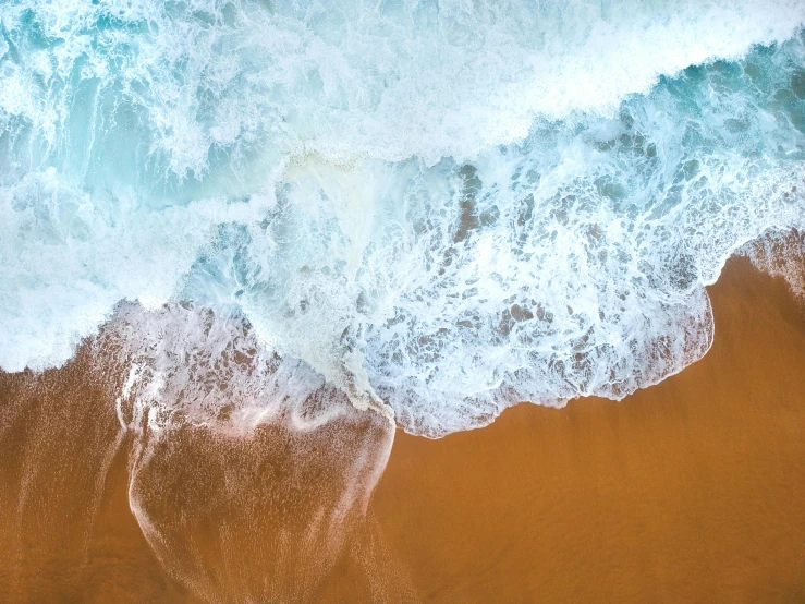 a person riding a surfboard on top of a sandy beach, pexels contest winner, minimalism, swirling liquids, looking down from above, roaring ocean in front, red sand beach