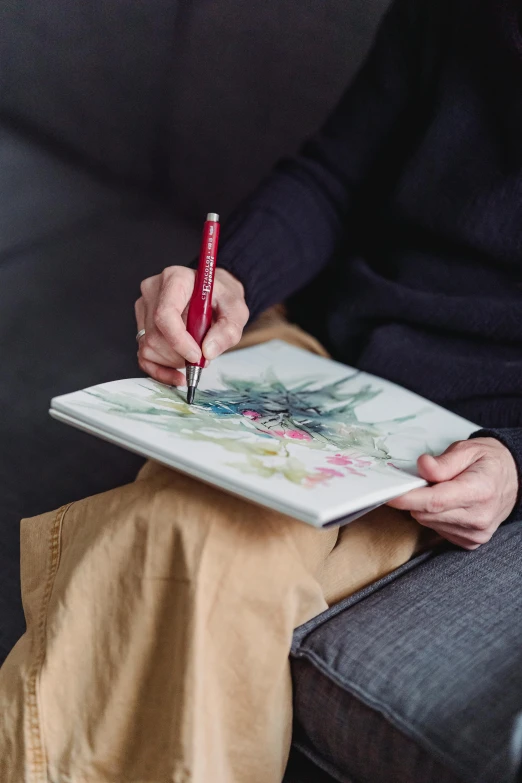 a person sitting on a couch drawing with a red pen, inspired by Matthias Grünewald, visual art, masterful detailed watercolor, botanic watercolors, delicate and precise brushwork, painting come to life