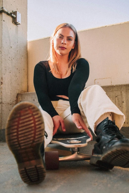 a woman sitting on top of a skateboard, inspired by Elsa Bleda, trending on unsplash, renaissance, non binary model, pants, low quality photo, headshot