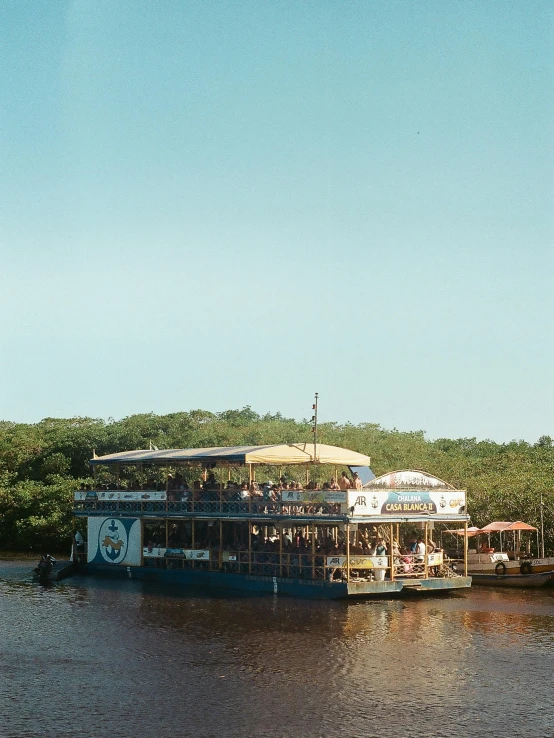 a boat that is sitting in the water, bar, & a river, brazilian, exterior shot