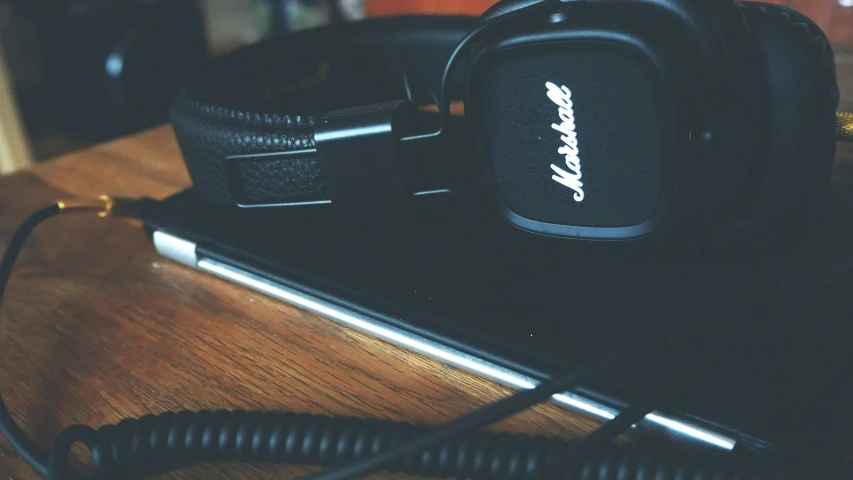 a pair of headphones sitting on top of a wooden table, an album cover, by Adam Marczyński, unsplash, banner, gaming, closeup - view, iphone wallpaper