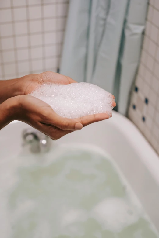 a person washing their hands in a bathtub, inspired by Elsa Bleda, unsplash, covered in salt, hard boiled, bubble bath, float