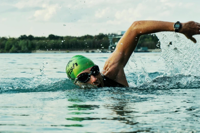 a person swimming in a body of water, green water, sports clothing, thumbnail, ironman