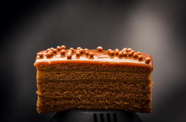 a piece of cake sitting on top of a spatula, by Daniel Gelon, pexels, brown mist, monaco, caramel. rugged, royal